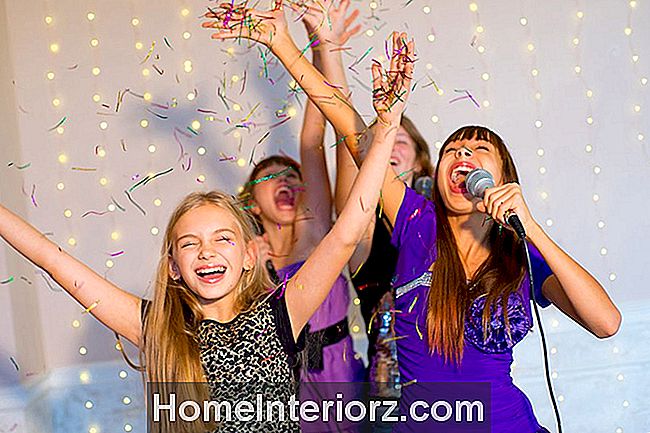 Grupė laimingų merginų, dainuojančių karaoke