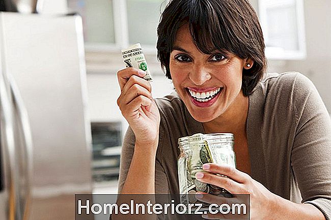 kvinna ler och håller en burk med pengar