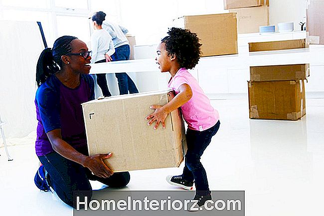 Smiling ema abistab väikelapsi tõsta pakitud liikuv kasti
