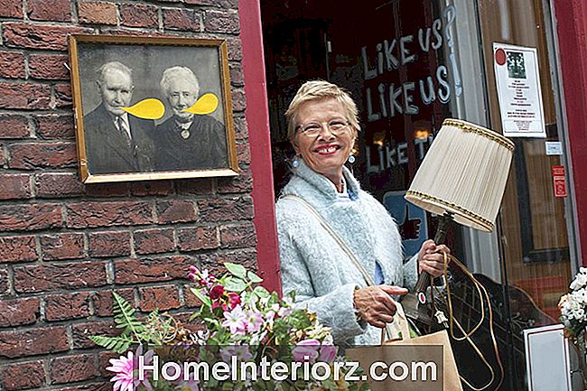 sieviete atstāj taupības veikalu ar vintage lampu