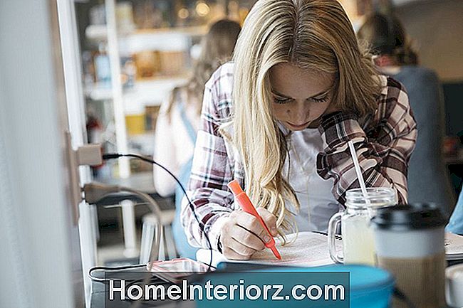 Keskittynyt valkoihoinen lukio tyttö opiskelija opiskelee kahvilassa