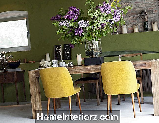 žalios spalvos sienos kambaryje su alyvmedžių gėlėmis